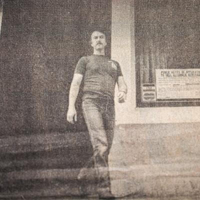 A vintage grainy photograph of a person walking