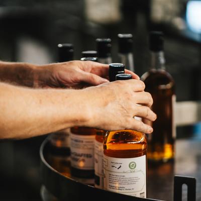 Hands holding various bottles.