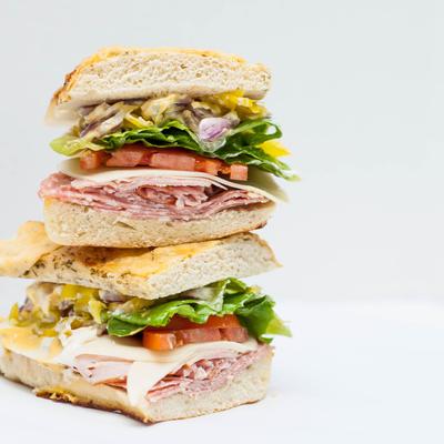Sicilian sandwich, with pepperoni, ham, salami, peppers, cheese, lettuce, tomato, and onion.