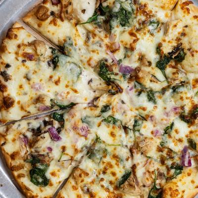 Chicken Florentine pizza with alfredo sauce, spinach, and mushrooms.