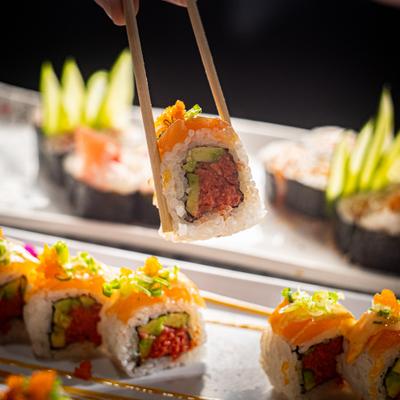 Spicy tuna sushi rolls, topped with salmon.