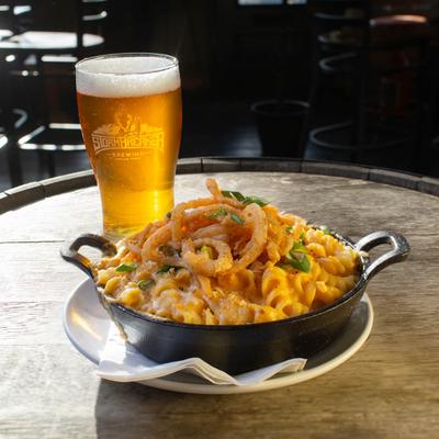 Mac and cheese bowl and a glass of beer.