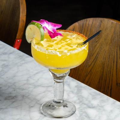 Yellow margarita with tajin rim, orchid and lime.