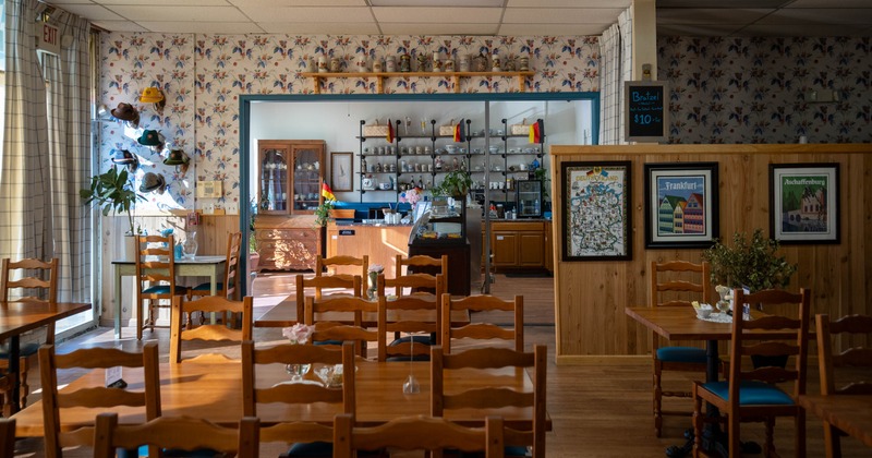 Interior with wooden furniture, decorative posters and cozy serving area