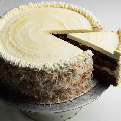 A slice of a cream-frosted cake being removed.