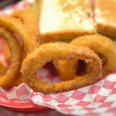 A BLT sandwich with onion rings.