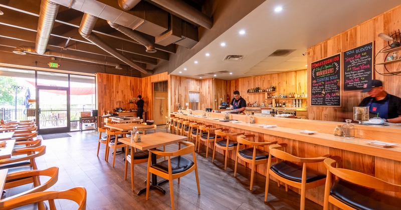 Interior, tables and chairs, bar and bar stools on the right