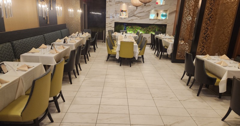 Interior of modern and cozy dining area with dining tables set for guests