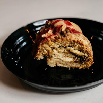 A slice of coffee cake on a black plate.
