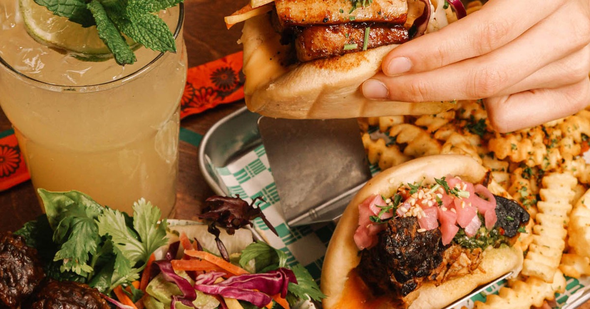 Bao buns with savory filling, crinkle fries, salad, and cocktail