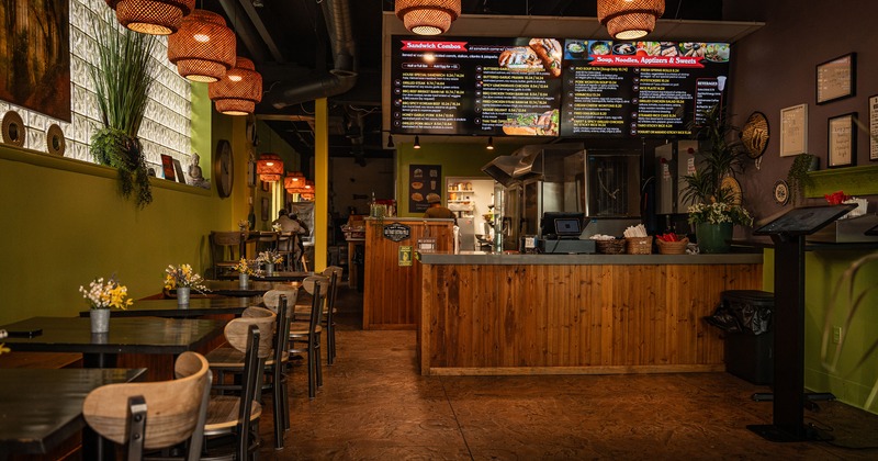 Cozy interior dining area with wooden tables lined up along the wall and an order counter