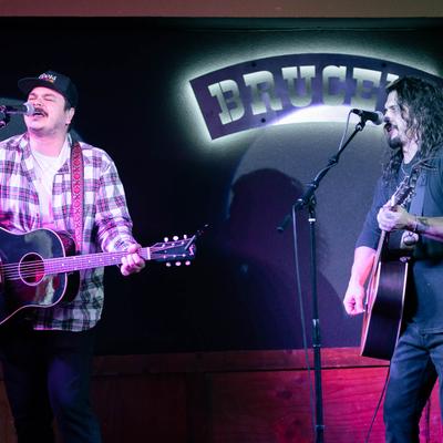 Two musicians performing on the stage inside.