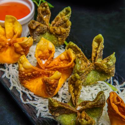 Crab Cheese Wontons served with a dipping sauce.