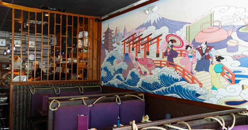 Interior, dining area, booths with tables, Japanese style mural on the wall