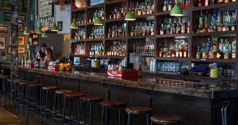 Interior, bar area, wooden top bar with stools, large drink shelf in the back