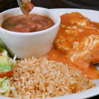 Mexican enchilada with red sauce, refried beans, and seasoned rice.
