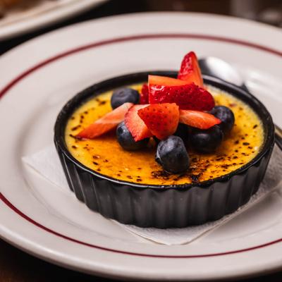 Burnt cream topped withe fresh blueberries and a strawberry.