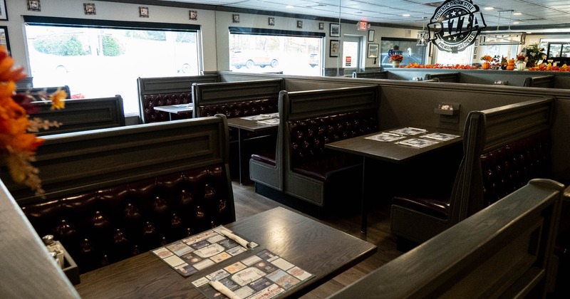 Interior, dining area, seating booths with wooden top tables, shop window in the back