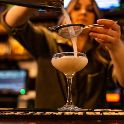 Bartender making a Bee's Knees cocktail