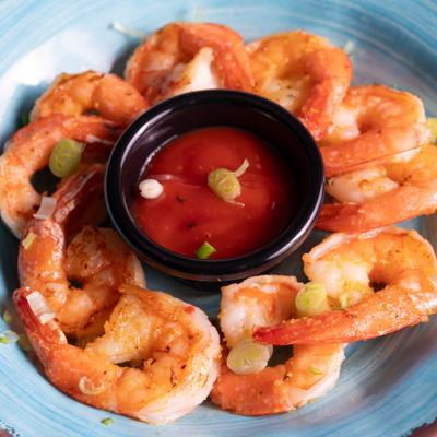 Garlic butter shrimp served with a side of red sauce.