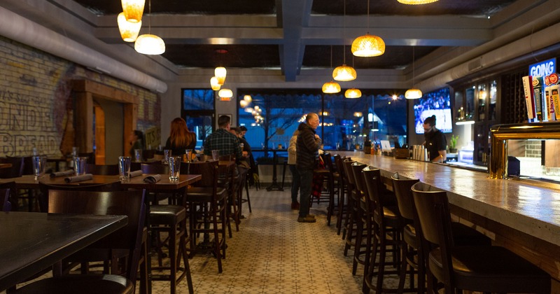 Interior, bar area with bar tables and stools near the bar