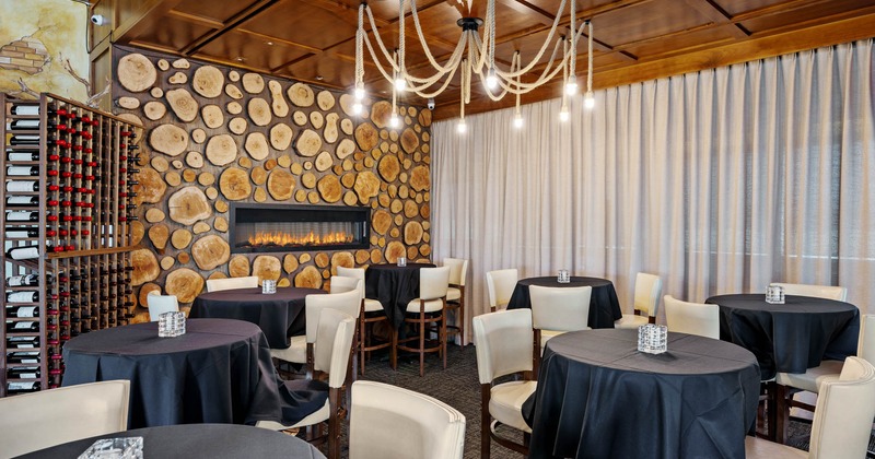 Dining area with empty tables, wine rack and a wall fire place