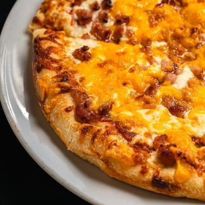 Bacon cheeseburger pizza topped with melted cheddar cheese.