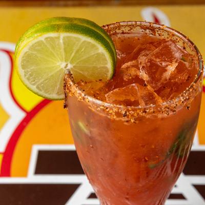 Michelada garnished with lime wheels.