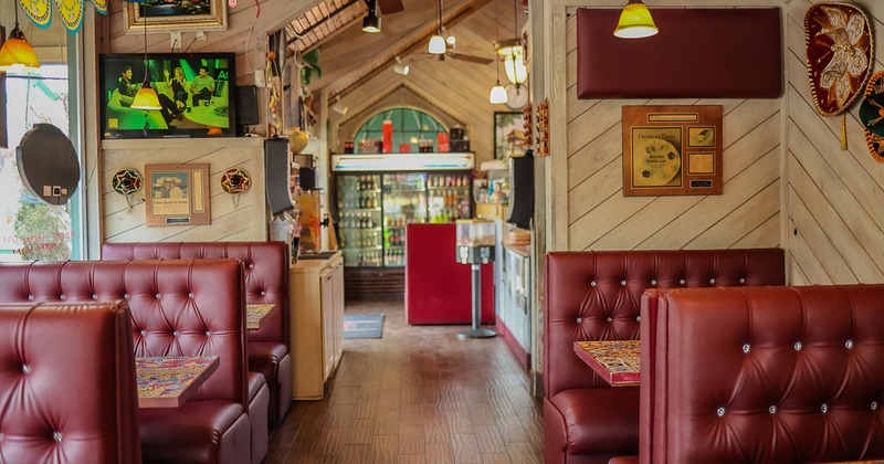 Interior dining area with upholstered booths lined up on two sides