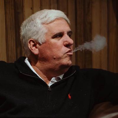 A person exhaling cigar smoke.