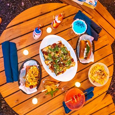 Blue cocktail and different types of food closeup