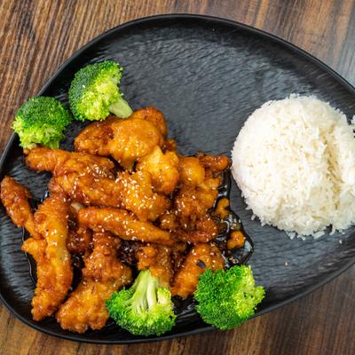 Chicken teriyaki served on a dark plate with rice and broccoli.