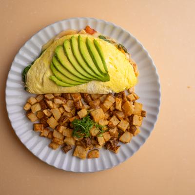 Grilled chicken and avocado omelette served with home fries.