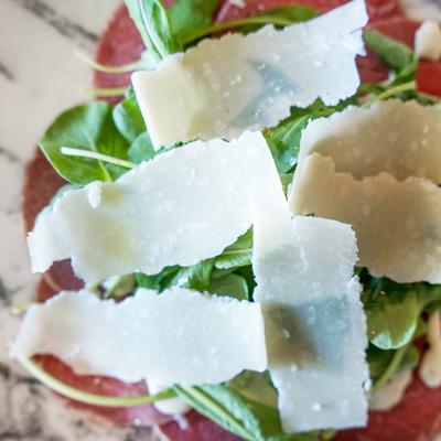 Carpaccio di Manzo (GF, Can Be DF) Raw beef tenderloin, aioli dressing, Jubilant Farms arugula, and Shaved Parmigiana.