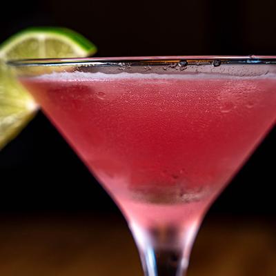 Extreme close up of Cosmopolitan glass, lime wedge garnish.