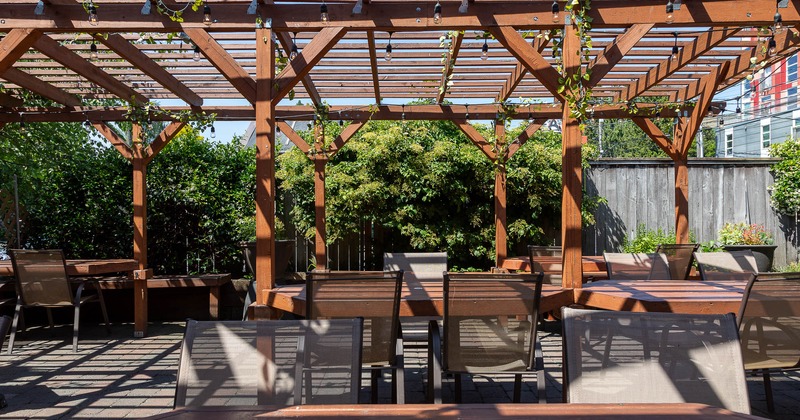 Patio with tables chairs and plants in background