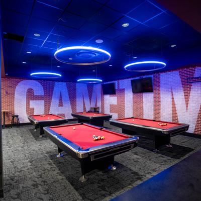Interior, billiards tables, carpet flooring, red brick walls.