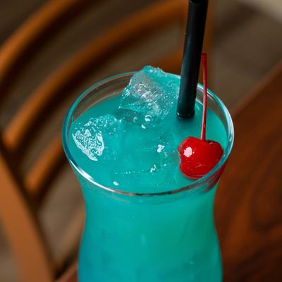 Blue Hawaiian cocktail garnished with a cherry.