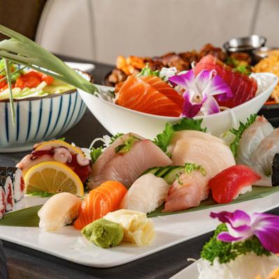 Colorful sushi and sashimi platter garnished with orchids.