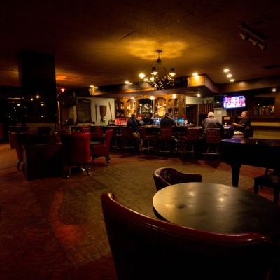 Interior, lounging chairs and tables, view of the bar.