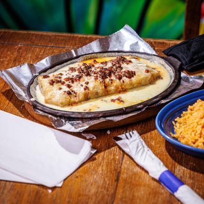 Chimichanga served in a skillet with rice on the side.