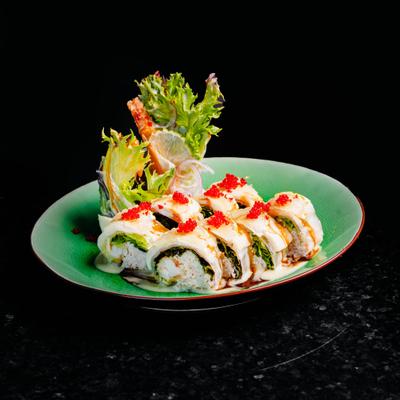 A serving of California rolls on a bright green plate, set on a dark table.