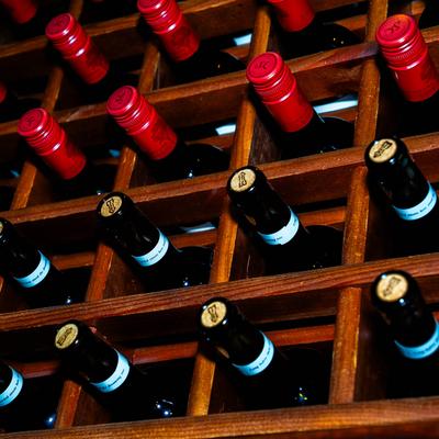 A wooden wine rack filled with assorted wine bottles.