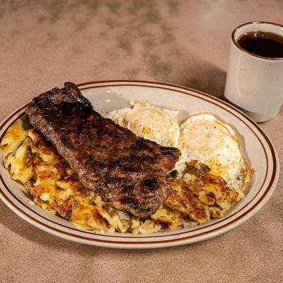 Steak with fried eggs and home fries.