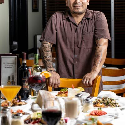 Restaurant chef in front of a table full of food.