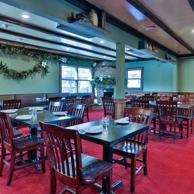Dining room with wooden tables set for service and Christmas decorations.