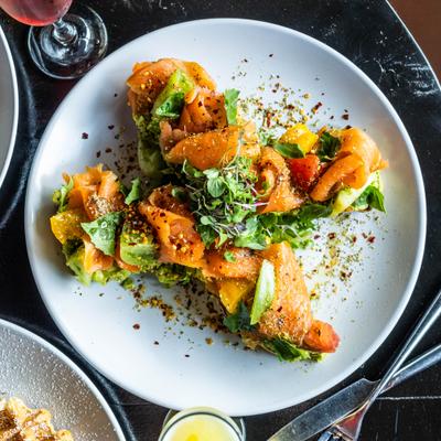 Avocado Taost topped with smoked salmon greens and garnishes.