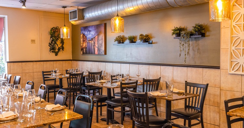 Fully set tables for guests, floral decorations on the wall