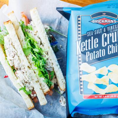 Chicken Salad sandwich served with a bag of chips.