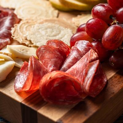 Cask Board with varety of cold cuts, cheeses and fruits, close-up.